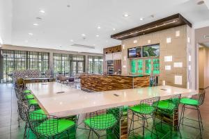 a large kitchen with a large island with green chairs at Courtyard by Marriott Longview North in Longview