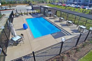an overhead view of a swimming pool with tables and chairs at Courtyard by Marriott Longview North in Longview