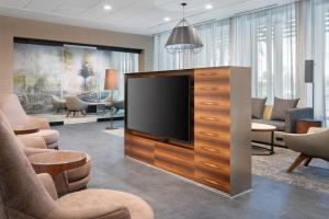 a living room with a flat screen tv and chairs at Courtyard by Marriott Port St. Lucie Tradition in Cana