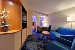 a hotel room with a couch and a table at Fairfield Inn & Suites Jackson Airport in Pearl