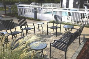een groep stoelen en tafels naast een zwembad bij Fairfield Inn & Suites Jackson Airport in Pearl