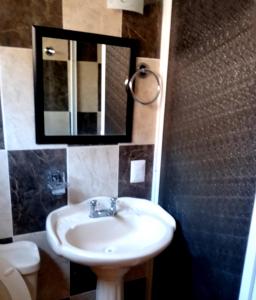 a bathroom with a sink and a mirror and a toilet at Nexpa cabañas Martha surf spot in Caleta de Campos