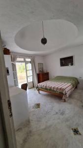 ein Schlafzimmer mit einem Bett in einem weißen Zimmer in der Unterkunft Maison de vacance pour les amateurs de la nature in Kelibia