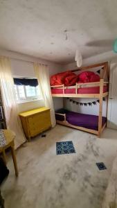 a room with two bunk beds and a table at Maison de vacance pour les amateurs de la nature in Kelibia