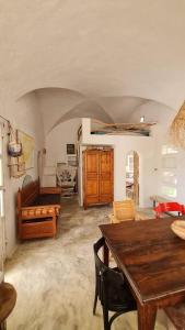 ein Wohnzimmer mit einem Holztisch und Stühlen in der Unterkunft Maison de vacance pour les amateurs de la nature in Kelibia
