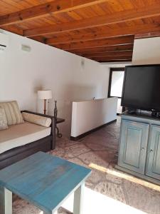 a living room with a couch and a flat screen tv at Carilo - semipiso 3 ambientes in Carilo