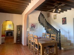 a dining room with a table and chairs and a staircase at Private villa large pool elevated quiet secluded location, near Mojacar in Antas