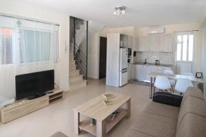 a living room with a couch and a tv and a kitchen at Marathon Beachside Homes next to Schinias Beach in Schinias