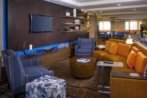 a lobby with a couch and chairs and a tv at Courtyard by Marriott Richmond Northwest in Henrico