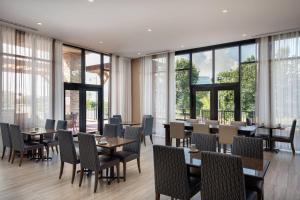 un restaurante con mesas, sillas y ventanas grandes en Residence Inn by Marriott Seattle South/Renton en Renton