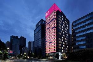 un grand bâtiment éclairé dans une ville dans l'établissement Aloft Tokyo Ginza, à Tokyo