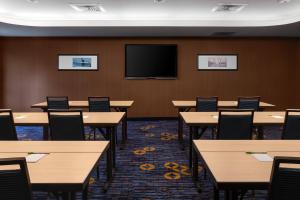 a conference room with tables and a flat screen tv at Courtyard by Marriott Portland Airport in South Portland