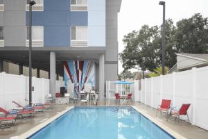 坦帕的住宿－TownePlace Suites by Marriott Tampa South，一座带椅子的游泳池以及一座建筑