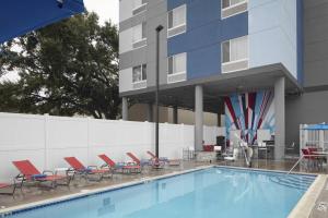 basen z krzesłami i budynek w obiekcie TownePlace Suites by Marriott Tampa South w mieście Tampa