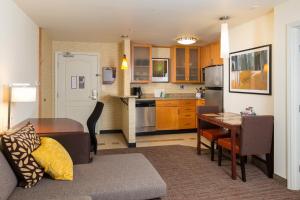 a living room and kitchen with a couch and a table at Residence Inn by Marriott Springfield Old Keene Mill in Springfield