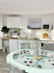 a kitchen with a table and a kitchen with white cabinets at Apartmán Eden in Bystrzyca