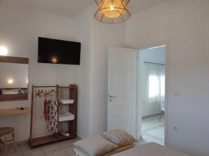 a living room with a bed and a tv on the wall at Sofia sea view apartment in Faros