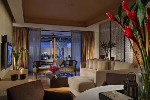 Singapore Marriott Tang Plaza Hotel في سنغافورة: غرفة معيشة مع أريكة وكراسي