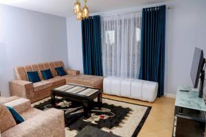 ein Wohnzimmer mit einem Sofa und einem Tisch in der Unterkunft Luxe Furnished Apartments Unit 3 in Meru