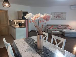 a vase of flowers on a table in a living room at Apart CENTAR UMAG EDDA Joakima Rakovca 7 E 52470-Umag in Umag