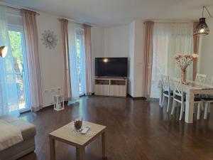 a living room with a television and a table at Apart CENTAR UMAG EDDA Joakima Rakovca 7 E 52470-Umag in Umag