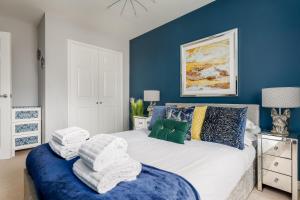 a bedroom with blue walls and a bed with towels on it at Puffling in Poole