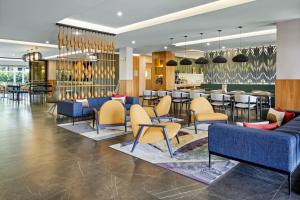 a lobby of a hotel with chairs and a bar at Courtyard by Marriott San Jose Escazu in San José