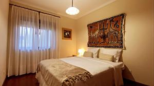 Schlafzimmer mit einem Bett mit Wandgemälde in der Unterkunft Ocean and River Apartment in Torreira