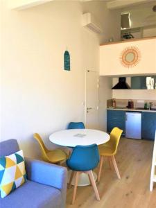a living room with a table and chairs and a kitchen at L'Appart de l'Hôtel de Ville in Arles +6 photos