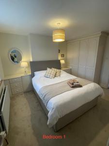 a bedroom with a large white bed with a light at Corner Cottage in Bewdley