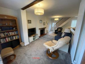 a living room with a blue couch and a tv at Corner Cottage in Bewdley