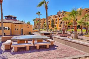 einen Picknicktisch in einem Park mit Palmen und Gebäuden in der Unterkunft Princesa de Penasco Condo B303 Sandy Beach Puerto Penasco in Puerto Peñasco