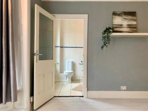 an open door to a bathroom with a toilet at Spacious 6BR Victorian Home in 14 Somerford Near Wolverhampton Centre with Free Parking in Willenhall