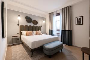 a hotel room with a large bed and a chair at Be Mate Colosseo in Rome