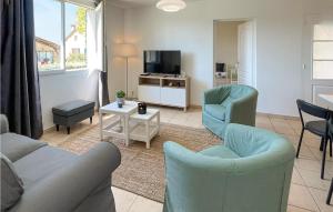 sala de estar con sofá, sillas y TV en 3 Bedroom Lovely Apartment In Maulon Darmagnac en Mauléon-dʼArmagnac