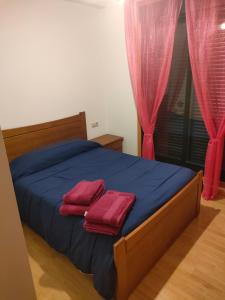 ein Schlafzimmer mit einem Bett mit zwei roten Handtüchern darauf in der Unterkunft David corzo in Nogueira de Ramuin