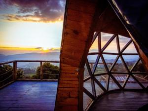 a view of the sunset from a room with a window at Glamping Entre Nubes in Zipacón