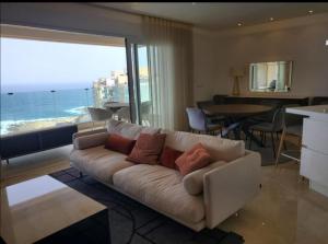 un soggiorno con divano e vista sull'oceano di 157 by Cast Renting Ltd a Sliema