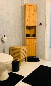 a bathroom with a toilet and a wooden cabinet at Laura's Cozy HOME in Madaba