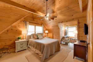 a bedroom with a bed and a ceiling fan at Creekside Bryson City Cabin with Private Hot Tub in Bryson City