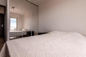- une chambre avec un lit blanc et un miroir dans l'établissement Helios, Sanguinaires, vue mer magnifique, T2 4pers, à Ajaccio