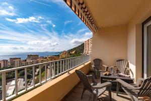 einen Balkon mit einem Tisch und Stühlen sowie Meerblick in der Unterkunft Helios, Sanguinaires, vue mer magnifique, T2 4pers in Ajaccio