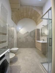 La salle de bains est pourvue de toilettes, d'un lavabo et d'une douche. dans l'établissement Lecce Santa Chiara Terrace piano rialzato, à Lecce