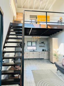 uma sala de estar com uma escada num loft em Bird Nest Lodge em Durban