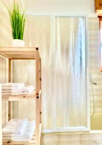 y baño con ducha y toallas en las estanterías. en "Le Camere di Beppe", Ampio e Luminoso Appartamento a Lecce, en Lecce