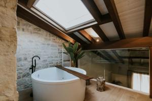 a bath tub in a bathroom with a skylight at Puracepa - Urban Suites in Haro