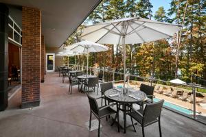 a patio with tables and chairs and umbrellas at The StateView Hotel, Autograph Collection in Raleigh