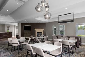 a dining room with tables and chairs and a fireplace at Residence Inn Tampa Oldsmar in Oldsmar