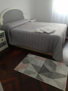ein Schlafzimmer mit einem Bett und einem Teppich auf dem Boden in der Unterkunft O PISIÑO in Cambados