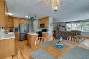 a kitchen and living room with a table and chairs at Cozy Anchorage Vacation Rental with Deck, Gas Grill in Anchorage